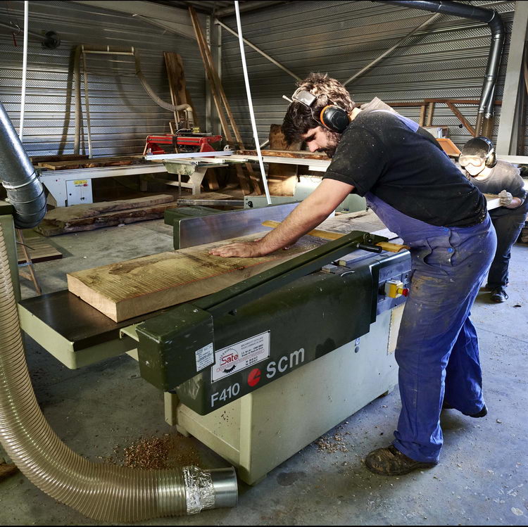 Olivier Pinel en train de dégauchir un plateau de bois